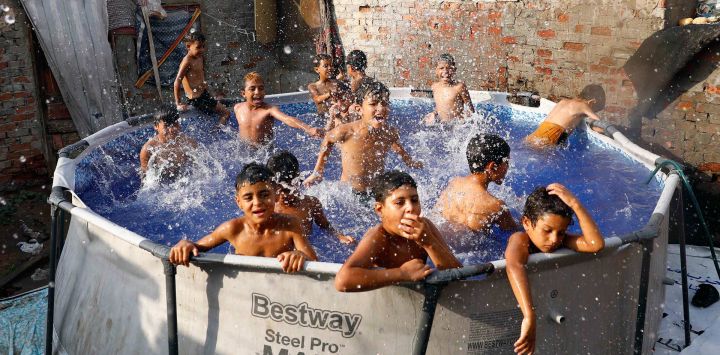 Niños se refrescan en una piscina móvil durante una ola de calor, en El Cairo, Egipto.