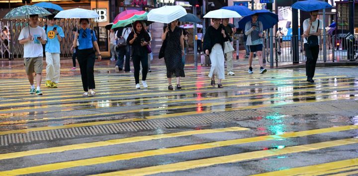 Personas sostienen paraguas mientras caminan por una calle, en Hong Kong, en el sur de China.