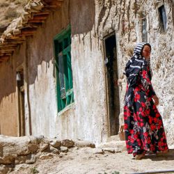 Esta fotografía muestra a una mujer hazara afgana caminando cerca de su casa en una aldea del distrito de Shibar, provincia de Bamiyán. Los afganos están sufriendo la crisis climática a través del agua, advierten organizaciones internacionales, enfatizando que las mujeres corren un riesgo especial. Tradicionalmente, las mujeres y las niñas realizan los viajes cada vez más largos para recoger agua, lo cual se ha vuelto más difícil desde que el gobierno talibán llegó al poder e impuso restricciones a la circulación, la educación y el trabajo de las mujeres. | Foto:Mohammad Faisal Naweed / AFP