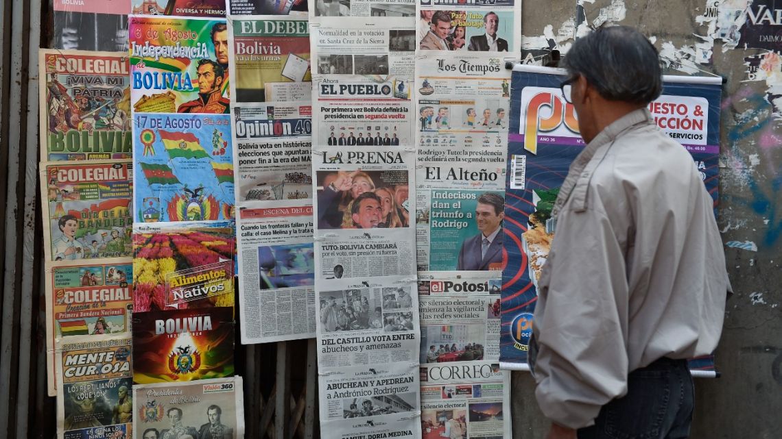 A man reads newspapers with front-page coverage of Bolivia's presidential election at a kiosk, in La Paz, on August 18, 2025.