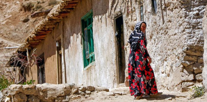 Esta fotografía muestra a una mujer hazara afgana caminando cerca de su casa en una aldea del distrito de Shibar, provincia de Bamiyán. Los afganos están sufriendo la crisis climática a través del agua, advierten organizaciones internacionales, enfatizando que las mujeres corren un riesgo especial. Tradicionalmente, las mujeres y las niñas realizan los viajes cada vez más largos para recoger agua, lo cual se ha vuelto más difícil desde que el gobierno talibán llegó al poder e impuso restricciones a la circulación, la educación y el trabajo de las mujeres.