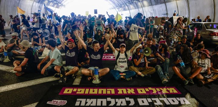 Familiares y simpatizantes de israelíes retenidos como rehenes por militantes de Hamás en Gaza desde los ataques del 7 de octubre de 2023 corearon consignas mientras bloqueaban el tráfico en un túnel durante una protesta exigiendo la acción del gobierno para asegurar su liberación en Jerusalén.
