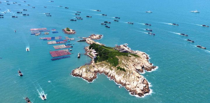 Vista aérea tomada con un dron de botes pesqueros zarpando de un puerto pesquero tras el fin de la prohibición de pesca estacional, en el distrito de Lianjiang de Fuzhou, en la provincia de Fujian, en el sureste de China.