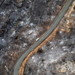 Esta vista aérea muestra una carretera que atraviesa terrenos arrasados por los incendios forestales, cerca del pueblo de Jonquieres, en el departamento de Aude, en el sur de Francia. | Foto:LIONEL BONAVENTURE / AFP