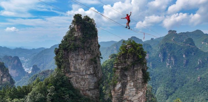 Imagen tomada con un dron de Stijn, de Bélgica, compitiendo durante el Campeonato "Rey del Slackline" 2025, en el punto escénico de Huangshizhai, en la provincia de Hunan, en el centro de China. Unos 20 atletas de élite de "Slackline" o caminata sobre cuerda de China, Francia, Brasil y otros países y regiones compitieron en el evento.