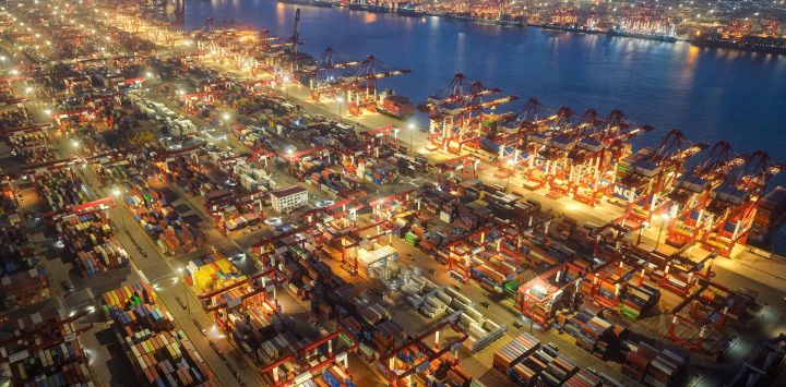 Se ven contenedores en el puerto de Qingdao, en la provincia oriental china de Shandong, después del atardecer. China y Estados Unidos retrasaron la aplicación de aranceles más altos a las importaciones del otro durante 90 días, horas antes de que expirara una tregua comercial entre las dos economías más grandes del mundo.