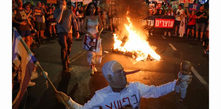 Un manifestante con una máscara que representa al primer ministro israelí, Benjamin Netanyahu, gesticula durante una manifestación organizada por las familias de los rehenes retenidos por militantes palestinos en Gaza desde 2023, exigiendo su liberación en Tel Aviv.