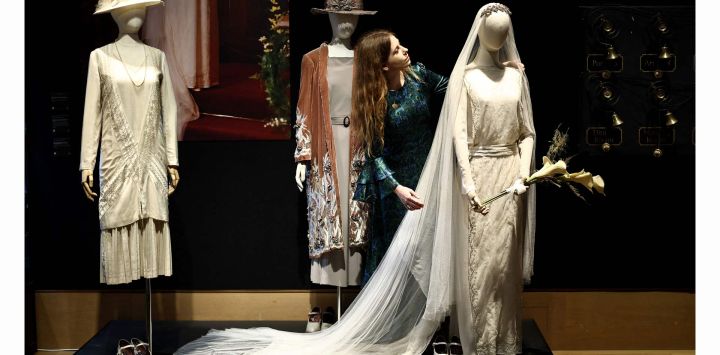 Un miembro del personal de una casa de subastas observa un vestido de novia perteneciente al personaje Lady Mary de la serie de televisión y cine Downton Abbey durante una vista previa de prensa para una exhibición de accesorios, vestuario y otros artículos de la franquicia antes de su subasta, en el centro de Londres.