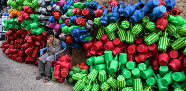 Un niño afgano que vende latas de plástico espera a los clientes en un mercado de Mazar-i-Sharif.