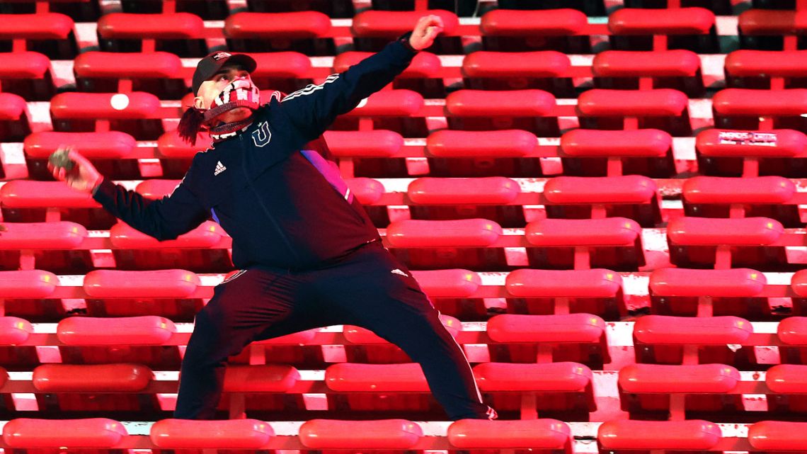 A fan of Universidad de Chile prepares to throw a stone during the interruption of the Copa Sudamericana round of 16 second leg football match between Argentina's Independiente and Chile's Universidad de Chile at the Libertadores de America stadium in Avellaneda, Buenos Aires Province, Argentina on August 20, 2025. 