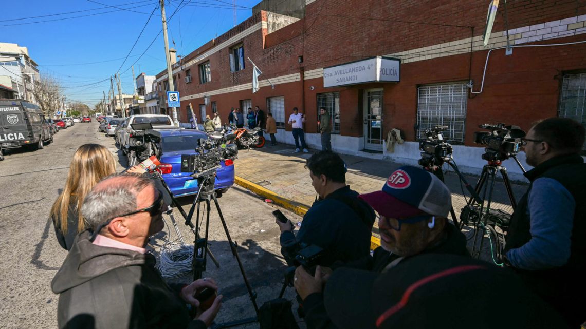Members of the media work outside a police station where fans of Universidad de Chile are detained a day after the interruption of the Copa Sudamericana round of 16 second leg football match between Argentina's Independiente and Chile's Universidad de Chile in Avellaneda, Buenos Aires province, on August 21, 2025, due to clashes between rival fans. 