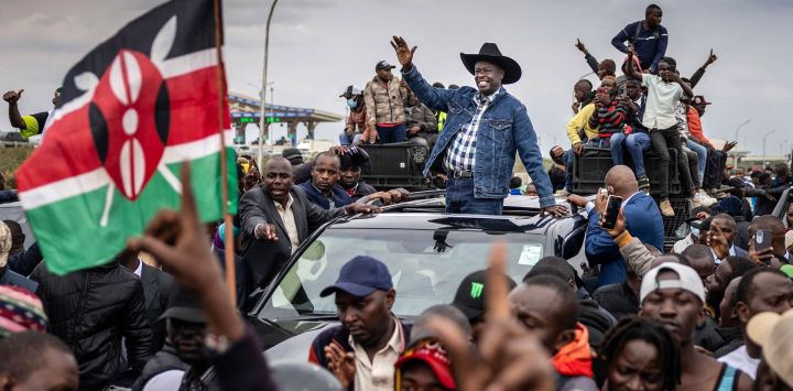 El exvicepresidente keniano y líder de la oposición del Partido Democracia para los Ciudadanos (DCP), Rigathi Gachagua (centro), saluda desde un automóvil mientras miles de simpatizantes se congregan para darle la bienvenida a su llegada a Nairobi.