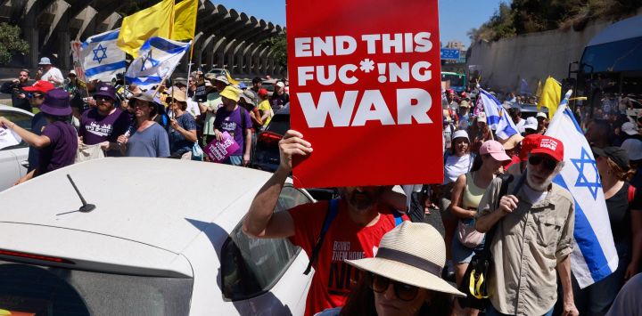 Familiares y simpatizantes de israelíes retenidos como rehenes por militantes de Hamás en Gaza desde los ataques del 7 de octubre de 2023, portan pancartas y banderas nacionales durante una protesta en Jerusalén, exigiendo la acción del gobierno para asegurar su liberación.
