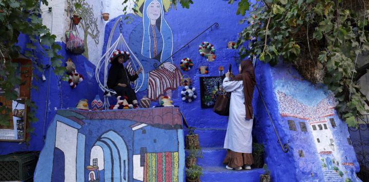 Una mujer posa para una foto en la medina de Chefchaouen, ciudad del noroeste de Marruecos, conocida por sus edificios en tonos azules.
