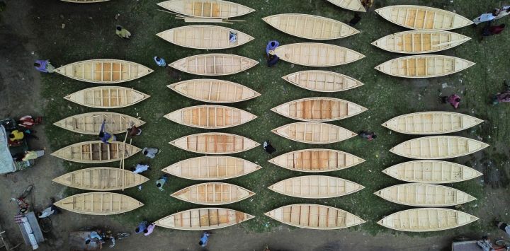 Vista aérea tomada con un dron de un mercado local de botes de madera hechos a mano, en Manikganj, Bangladesh. Las vías fluviales juegan un papel fundamental para las comunicaciones en Bangladesh, donde los botes tradicionales y las embarcaciones pequeñas siguen ofreciendo un transporte asequible y conveniente.