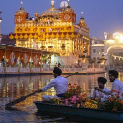 Devotos sijs transportan flores en un bote mientras decoran el Templo Dorado en vísperas del aniversario de la primera instalación del libro sagrado sij Guru Granth Sahib en Amritsar, India. | Foto:Narinder Nanu / AFP