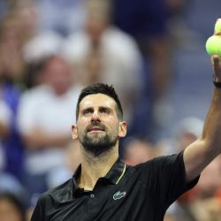 El serbio Novak Djokovic se prepara para lanzar pelotas de tenis autografiadas a los aficionados tras ganar su partido de primera ronda individual masculino contra el estadounidense Learner Tien en el primer día del torneo US Open de tenis en el Centro Nacional de Tenis Billie Jean King de la USTA en la ciudad de Nueva York. | Foto:CHARLY TRIBALLEAU / AFP