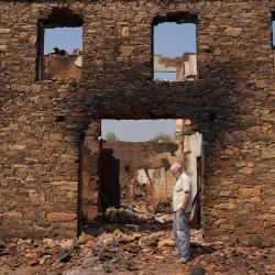 Un hombre permanece de pie frente a una casa quemada en ruinas tras un incendio forestal en el pueblo de Castrocalbón, noroeste de España. | Foto:Cesar Manso / AFP