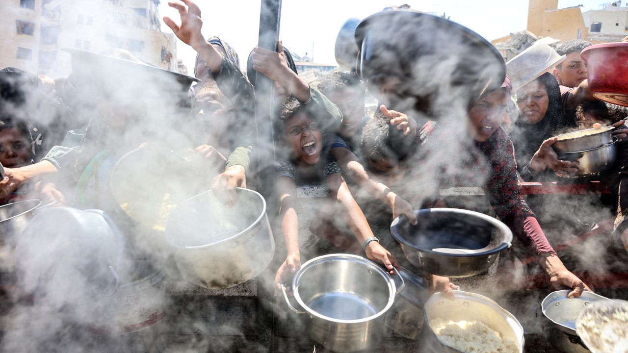 Palestinos extienden ollas vacías frente a un comedor social para recibir arroz cocido, en la ciudad de Gaza. Naciones Unidas declaró oficialmente la hambruna en Gaza el 22 de agosto, culpando a la "obstrucción sistemática" de la ayuda por parte de Israel durante más de 22 meses de guerra. El primer ministro, Benjamin Netanyahu, desestimó rápidamente las conclusiones. | Foto:OMAR AL-QATTAA / AFP