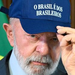 El presidente de Brasil, Luiz Inácio Lula da Silva, se coloca una gorra con la leyenda "Brasil es de los brasileños" durante una reunión ministerial en el Palacio de Planalto, Brasilia. | Foto:EVARISTO SA / AFP