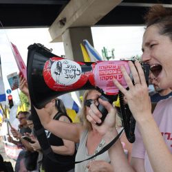 Un manifestante corea consignas durante una manifestación organizada por las familias de los rehenes israelíes tomados cautivos en la Franja de Gaza desde octubre de 2023, exigiendo medidas para asegurar su liberación y un alto el fuego en la guerra contra Hamás en Tel Aviv. | Foto:JACK GUEZ / AFP