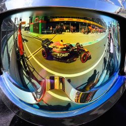 El coche del piloto holandés de Red Bull Racing, Max Verstappen, se ve reflejado en el casco de un comisario en el pit lane durante la sesión de clasificación Q2 del Gran Premio de los Países Bajos de Fórmula 1 en el circuito de Zandvoort, en el oeste de los Países Bajos. | Foto:JOHN THYS / AFP
