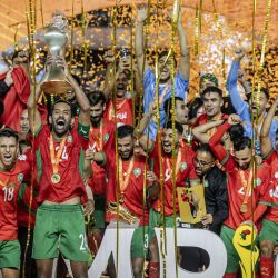 El defensor de Marruecos, Mohamed Rabie Hrimat, sostiene el trofeo mientras Marruecos celebra su victoria en la final del Campeonato Africano de Naciones (CHAN) contra Madagascar en el estadio Kasarani de Nairobi. | Foto:LUIS TATO / AFP
