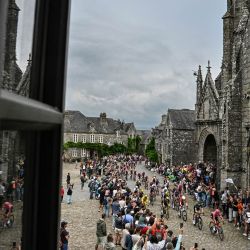 El pelotón de ciclistas pasa junto a la iglesia de Saint-Ronan en Locronan, durante la segunda etapa (de 9) de la cuarta edición del Tour de Francia femenino, 110,4 km de Brest a Quimper. | Foto:JULIEN DE ROSA / AFP