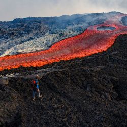Esta vista aérea muestra a un hombre de pie cerca de un flujo de lava en el volcán Etna. La erupción del Etna comenzó el 10 de agosto y se mantuvo activa durante las últimas semanas. | Foto:Giuseppe Distefano / AFP