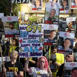 Manifestantes alzan pancartas durante una manifestación organizada por las familias de israelíes secuestrados por militantes palestinos en la Franja de Gaza, para exigir su liberación y un alto el fuego en la guerra en Gaza. | Foto:JACK GUEZ / AFP