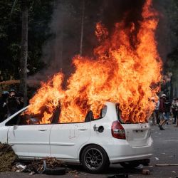 Un coche arde tras ser incendiado durante una protesta contra el Cuerpo de Brigadas Móviles (Brimob), tras la muerte de un mototaxista la noche anterior, frente a la sede de Brimob en Yakarta, Indonesia. | Foto:ADITYA AJI / AFP