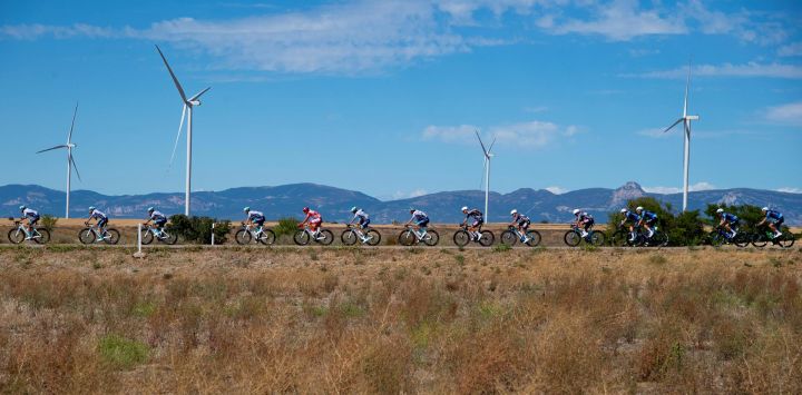 El pelotón pasa junto a aerogeneradores durante la octava etapa de la Vuelta a España, una carrera de 158 km entre Monzón Templario y Zaragoza.