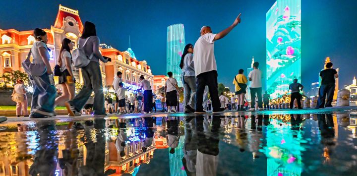 Imagen de personas disfrutando de la vista nocturna junto al río Haihe, en Tianjin, en el norte de China.