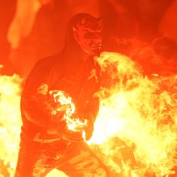 Un joven enmascarado asiste al "Festival de la Bola de Fuego" en Nejapa, El Salvador. Esta fiesta tradicional, que data de 1922, se celebra en honor a San Jerónimo y recuerda la erupción del volcán de San Salvador en 1658 que destruyó Nejapa. | Foto:MARVIN RECINOS / AFP