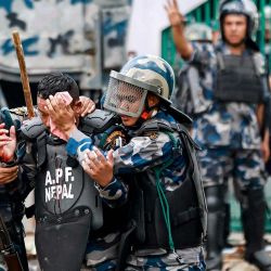La policía antidisturbios carga a un compañero herido mientras los manifestantes lanzan piedras durante una protesta frente al Parlamento en Katmandú, condenando la prohibición de las redes sociales y la corrupción gubernamental. Al menos 16 manifestantes murieron después de que la policía nepalí disparara balas de goma, gases lacrimógenos y cañones de agua para dispersar a los manifestantes que exigían que el gobierno levantara la prohibición de las redes sociales y combatiera la corrupción. | Foto:PRABIN RANABHAT / AFP