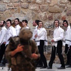 Las fuerzas de seguridad israelíes vigilan a colonos israelíes que recorren el antiguo mercado del lado palestino de Hebrón, en la Cisjordania ocupada. | Foto:HAZEM BADER / AFP
