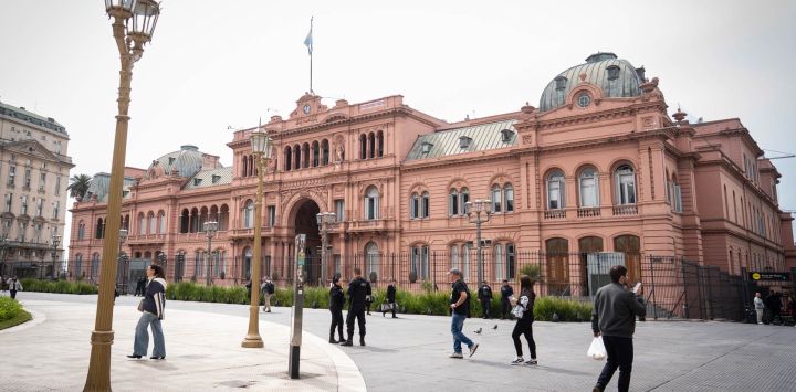 Personas caminan frente a la Casa Rosada, sede del gobierno argentino, en la ciudad de Buenos Aires, capital de Argentina. Los valores del peso argentino, junto a las acciones y los títulos públicos del país, reportaron fuertes caídas, tras el revés electoral que tuvo el partido gobernante en las elecciones legislativas realizadas el domingo en la provincia de Buenos Aires.