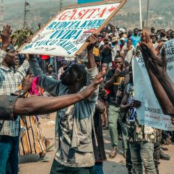 Un manifestante sostiene una pancarta en suajili que dice "¡Devuelvan al General Gasita, no lo queríamos!", mientras otros señalan a un soldado de las Fuerzas Armadas de la República Democrática del Congo durante una manifestación en Uvira. Las manifestaciones estallaron en la ciudad de Uvira, al este de la República Democrática del Congo, contra la presencia del general del ejército congoleño Olivier Gasita, oficial designado por el presidente Tshisekedi para dirigir la inteligencia militar de la 33.ª Región Militar. La sociedad civil lo acusa de haber facilitado la caída de la ciudad de Bukavu en manos del grupo M23 en febrero de 2025. | Foto:AFP