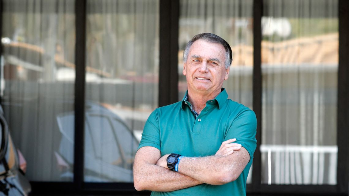 Brazilian ex-president Jair Bolsonaro gestures at the garage of his residence in Brasília on September 11, 2025