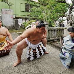 El luchador de sumo japonés "yokozuna", Onosato (centro), participa en una ceremonia de entrada al ring en el santuario Nomi no Sukune de Tokio, antes del inicio del Gran Torneo de Sumo. | Foto:JAPAN POOL / JIJI Press / AFP