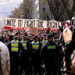 La gente alza pancartas y carteles durante una marcha de protesta contra el racismo en Melbourne para contrarrestar a los manifestantes antiinmigración y antigubernamentales de la manifestación de Save Australia. | Foto:William West / AFP