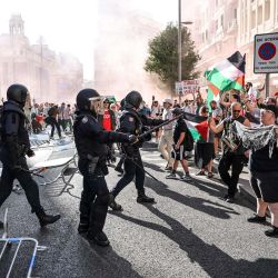 La policía se enfrenta a manifestantes pro-palestinos tras el derribo de las barreras de seguridad durante la 21.ª y última etapa de la Vuelta a España 2025, una carrera de 101 km entre Alalpardo y Madrid, en Madrid. Las autoridades reforzaron la seguridad para la última etapa de la Vuelta en Madrid, que se acortó ligeramente y contará con el despliegue de 1.100 policías en la capital española. | Foto:Thomas Coex / AFP