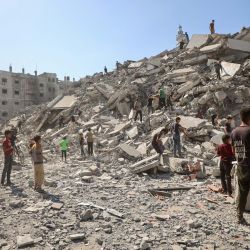 Palestinos buscan entre los escombros de la torre Al-Ghafari tras su destrucción por ataques aéreos israelíes en la ciudad de Gaza. El ejército israelí declaró que actuaría con "gran fuerza" en la ciudad de Gaza y ordenó a los residentes que abandonaran la ciudad, intensificando un asalto mortal contra el mayor centro urbano del territorio palestino. | Foto:OMAR AL-QATTAA / AFP
