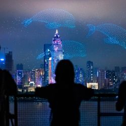 Personas observan una presentación con drones durante la ceremonia de apertura de la temporada cultural y artística del río Yangtse 2025, en Wuhan, en la provincia de Hubei, en el centro de China. | Foto:Xinhua/Wu Zhizun