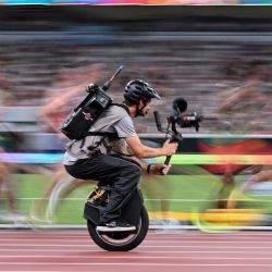 Un camarógrafo en un monociclo filma a atletas en acción mientras compiten en la final masculina de 10.000 m durante el Campeonato Mundial de Atletismo en Tokio. | Foto:KIRILL KUDRYAVTSEV / AFP