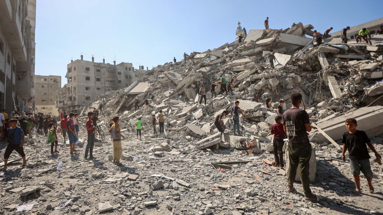 Palestinos buscan entre los escombros de la torre Al-Ghafari tras su destrucción por ataques aéreos israelíes en la ciudad de Gaza. El ejército israelí declaró que actuaría con "gran fuerza" en la ciudad de Gaza y ordenó a los residentes que abandonaran la ciudad, intensificando un asalto mortal contra el mayor centro urbano del territorio palestino. | Foto:OMAR AL-QATTAA / AFP