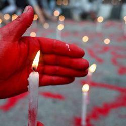 Una persona enciende velas durante un homenaje silencioso en el "Día Nacional de Luto" en honor a las víctimas de los enfrentamientos durante las recientes protestas, en el Mandala Maitighar de Katmandú, Nepal. | Foto:ARUN SANKAR / AFP