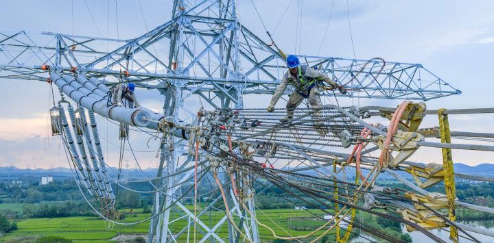 Imagen tomada con un dron de trabajadores realizando tareas de cableado para el proyecto de transmisión de corriente continua de ultra alta tensión de ±800 kV entre Gansu y Zhejiang, en el distrito de Nanling, en Wuhu, en la provincia de Anhui, en el este de China.