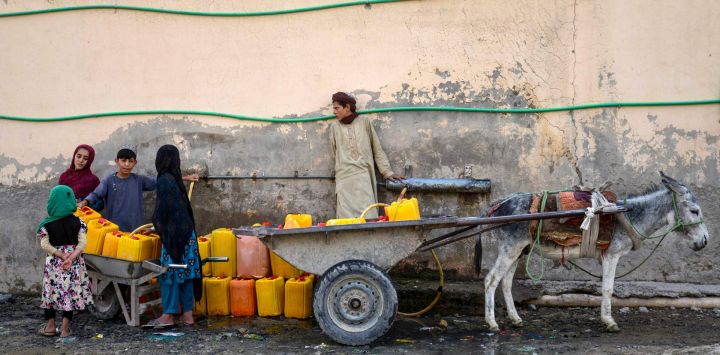 Niños afganos llenan bidones de agua en un grifo público en el distrito de Dand, provincia de Kandahar.