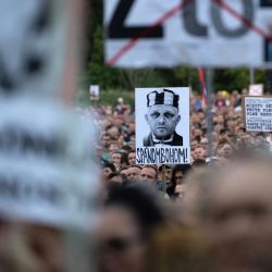 Un cartel que representa al primer ministro eslovaco, Robert Fico, como prisionero, y el cartel superior, que dice "Mal" (Zlo), son sostenidos por participantes que protestan contra las medidas de recorte presupuestarias propuestas por el gobierno durante una manifestación contra el primer ministro nacionalista Fico en Bratislava. | Foto:Joe Klamar / AFP